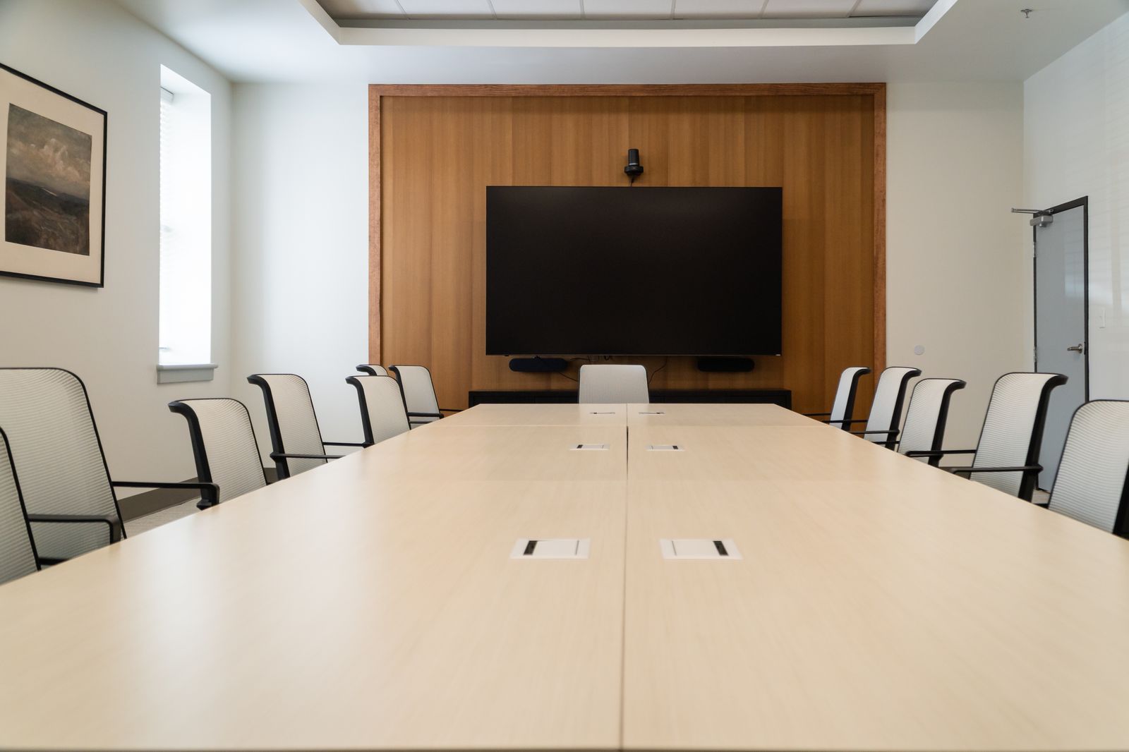 The 100-inch presentation display at the head of the conference table