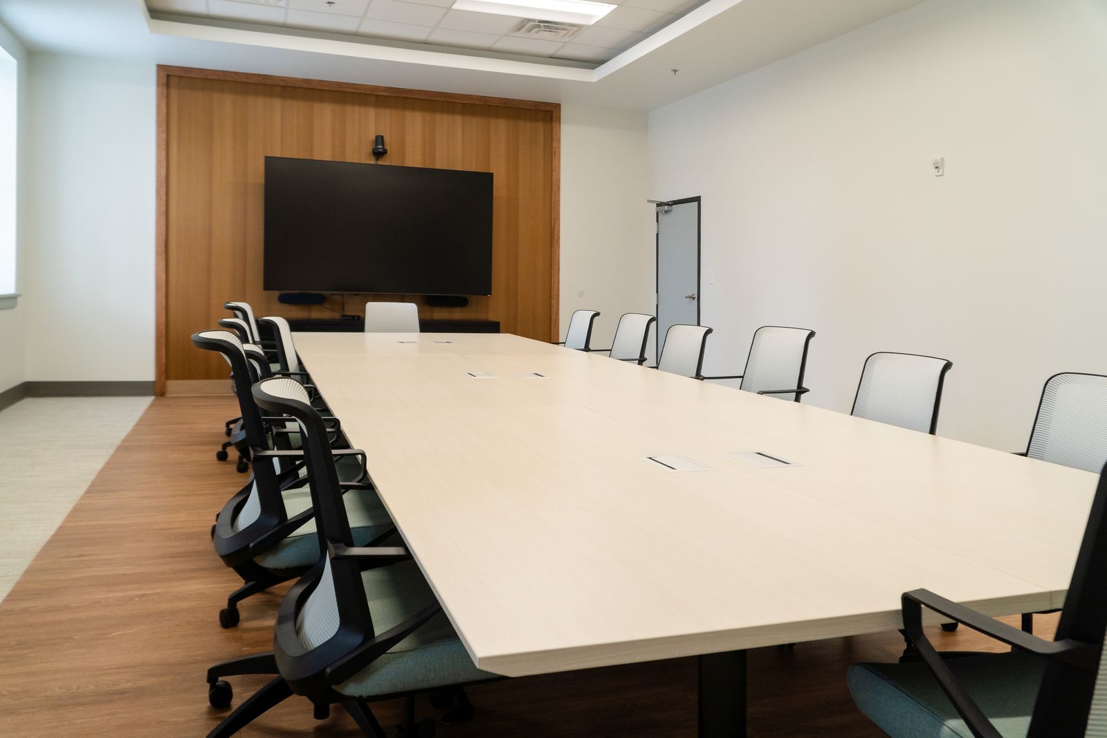 View down the conference table toward the display wall
